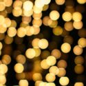 Blurred yellow / gold twinkling lights against a black background.