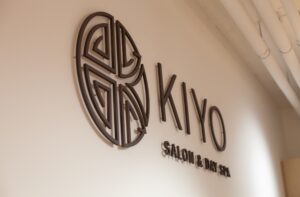 House of Kiyo interior signage. Black minimalist logo pin-mounted on white wall.